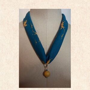 Bronze horse-print jersey fabric necklace with amber ceramic bead pendant.